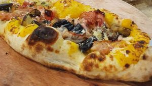 Sugestão de sabores de pizza: Pizza de creme de abobora cabotiá com pancetta, berinjela e tomate cereja 
